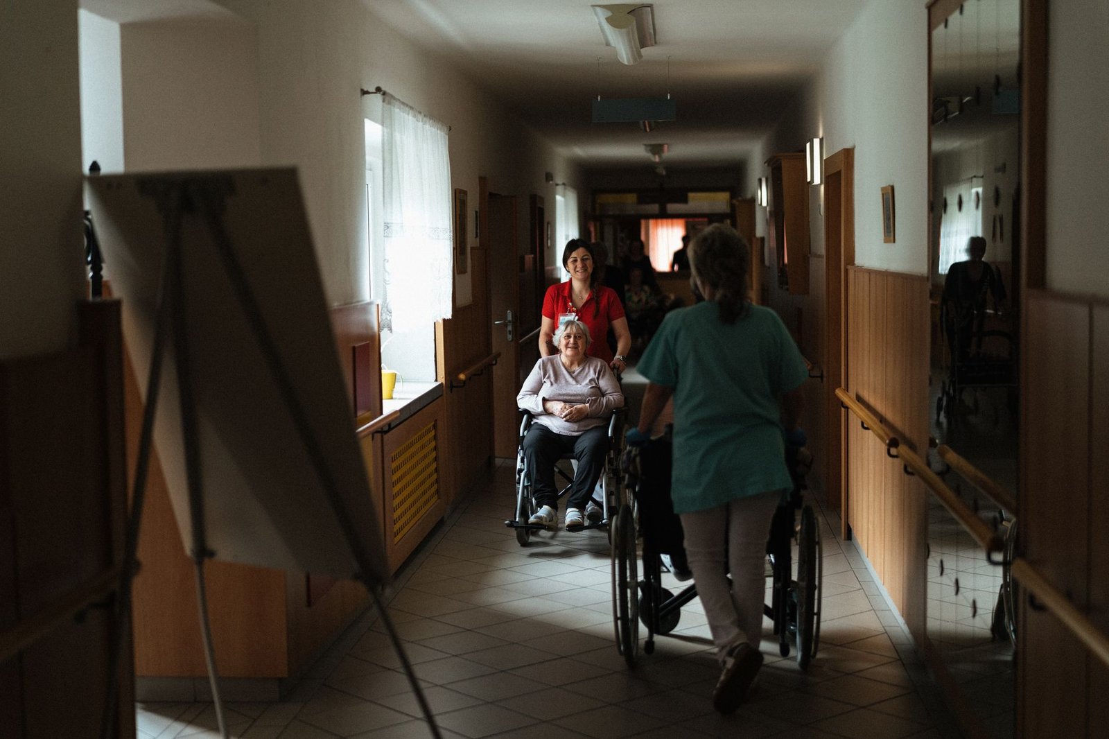Caregiver assisting a veteran resident, the kind of daily support found at state veterans homes for long-term care