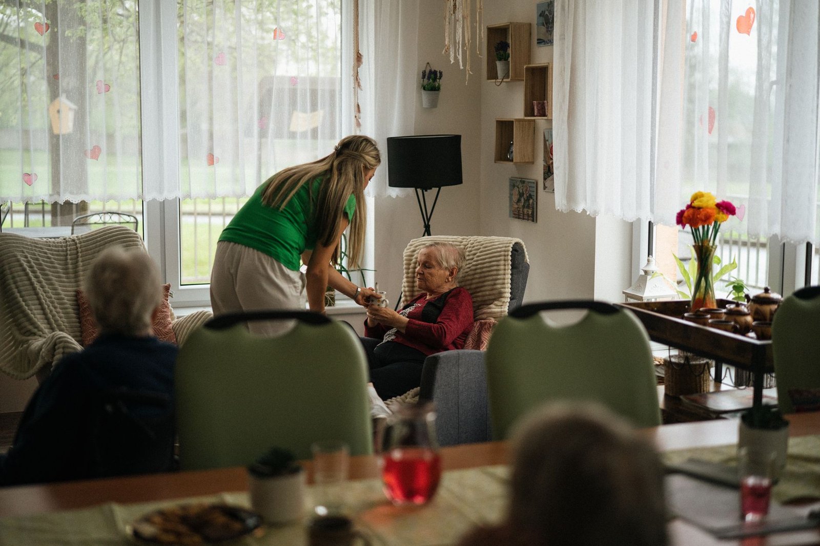 Veteran resident at one of the state veterans homes for long-term care, seated in a bright common room